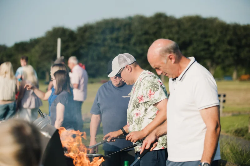 a group of people standing around a campfire