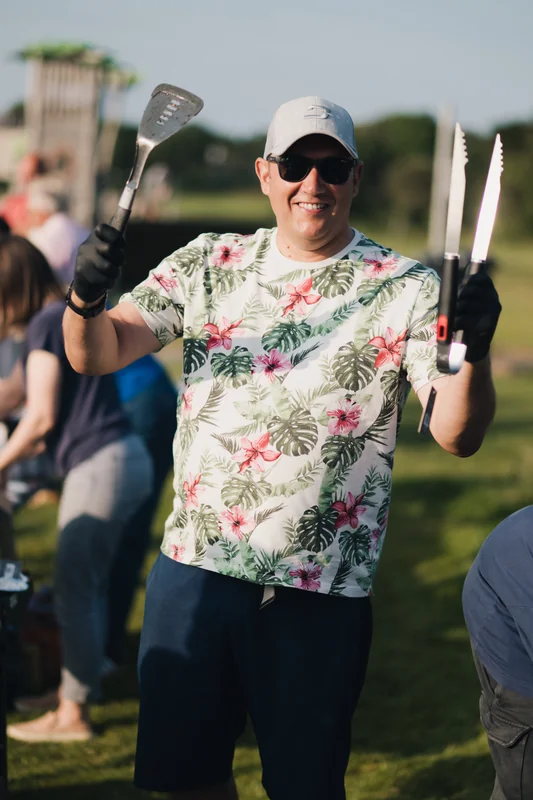 a man holding a pair of chopsticks in a crowd of people