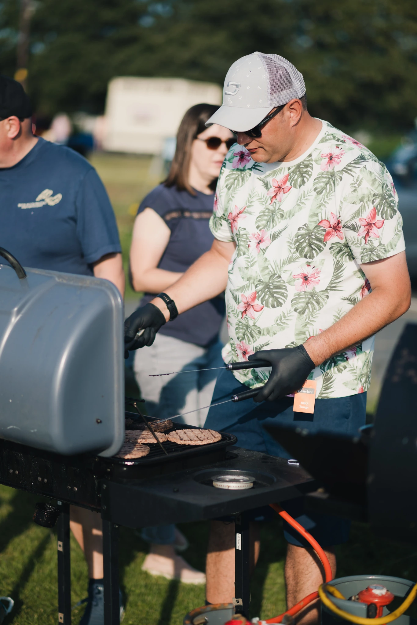 a man with a bbq grill in front of a crowd of people