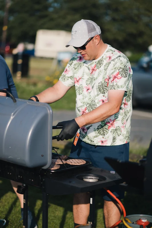 a man grilling a burger on a barbecue grill