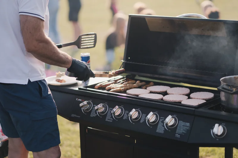 a man is cooking food on a bbq grill