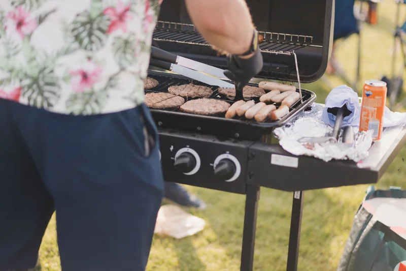 a man preparing food on a barbecue grill