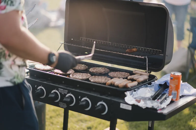 a man grilling burgers on a bbq grill
