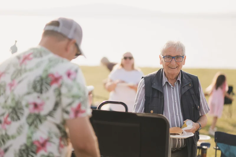 a man with a bbq grill and a plate of food in front of him
