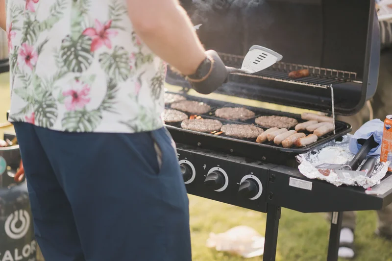 a man grilling burgers on a bbq grill