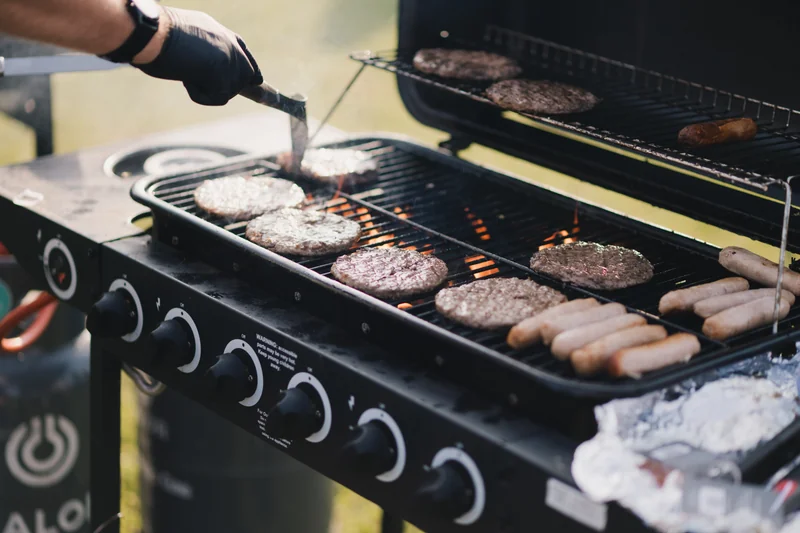 a person cooking food on a barbecue grill