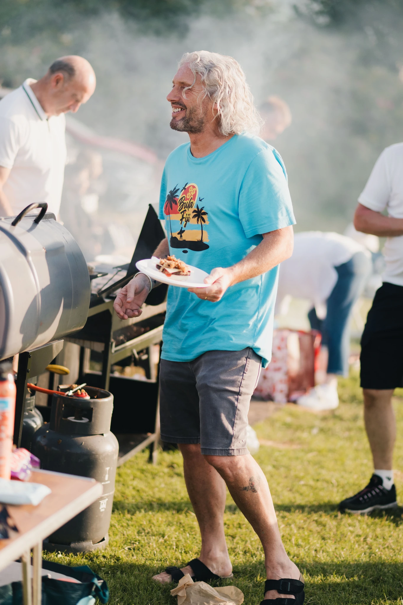 a man with a bbq grill in front of a crowd of people