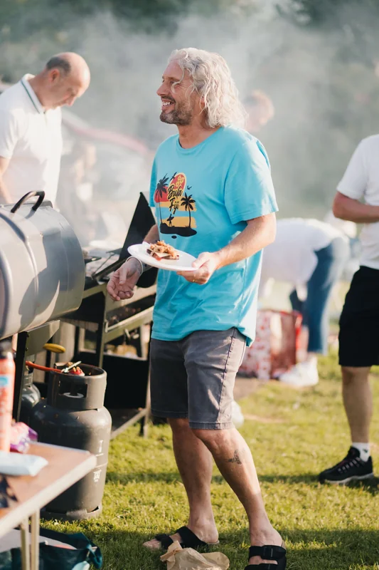 a man with a bbq grill in front of a crowd of people