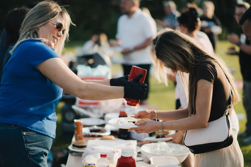 a woman is pouring sauce on a plate of food