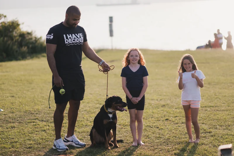 a man with a dog on a leash in a park