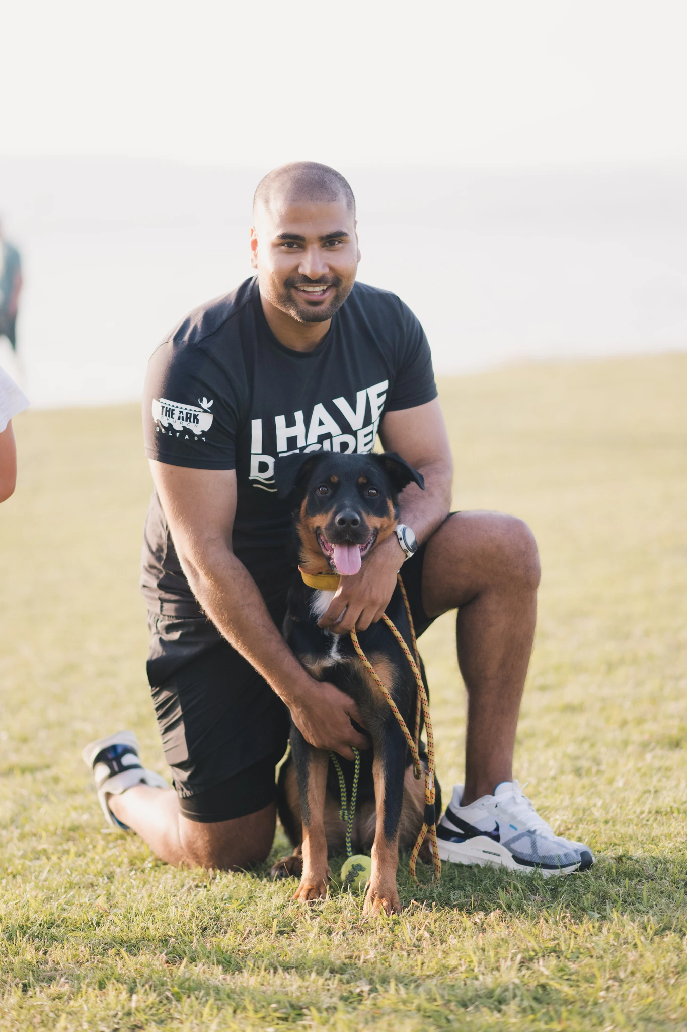a man with a dog on his lap in a park
