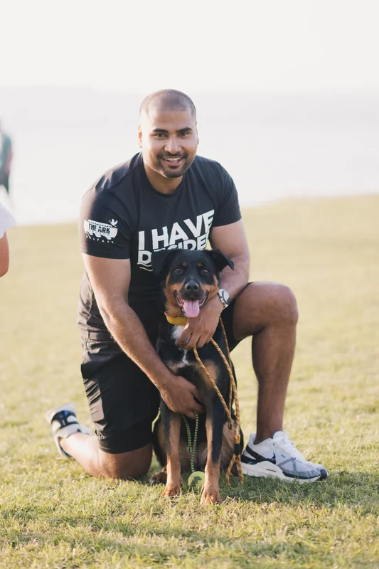 a man with a dog on his lap in a park