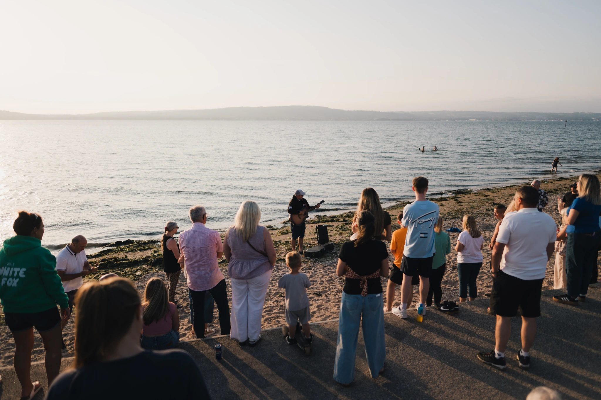 a group of people watching a sunset on the beach