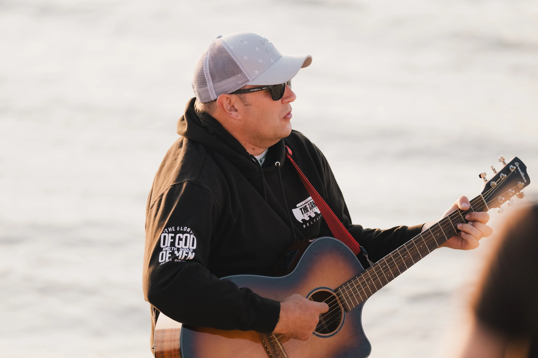 a man plays an acoustic guitar on the beach