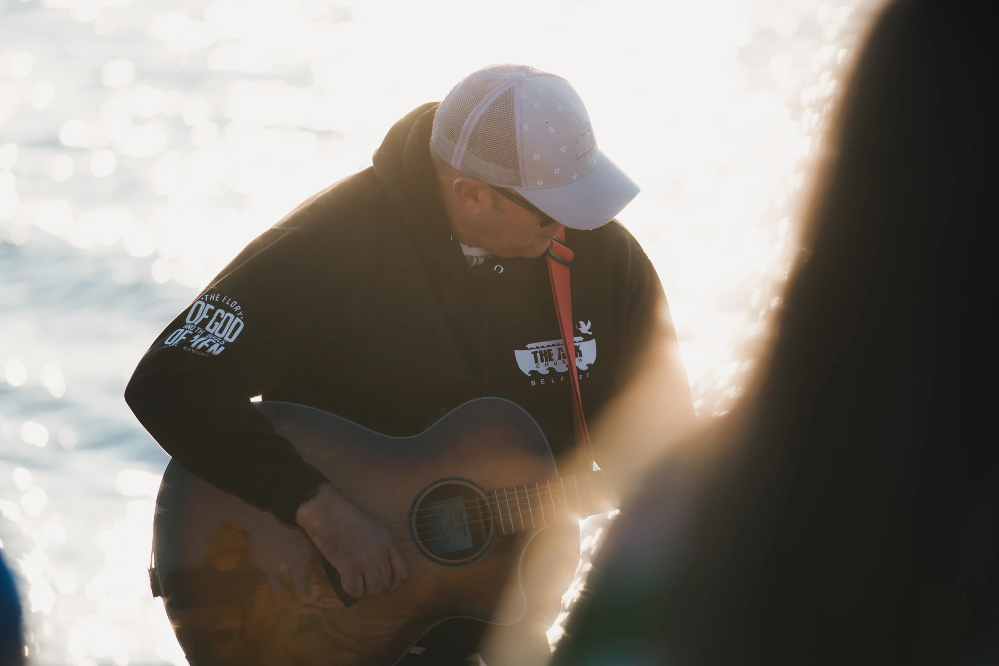 a man playing an acoustic guitar in front of a crowd