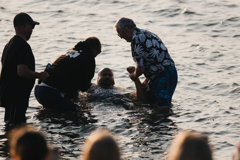 a man is being baptized by a woman in the water