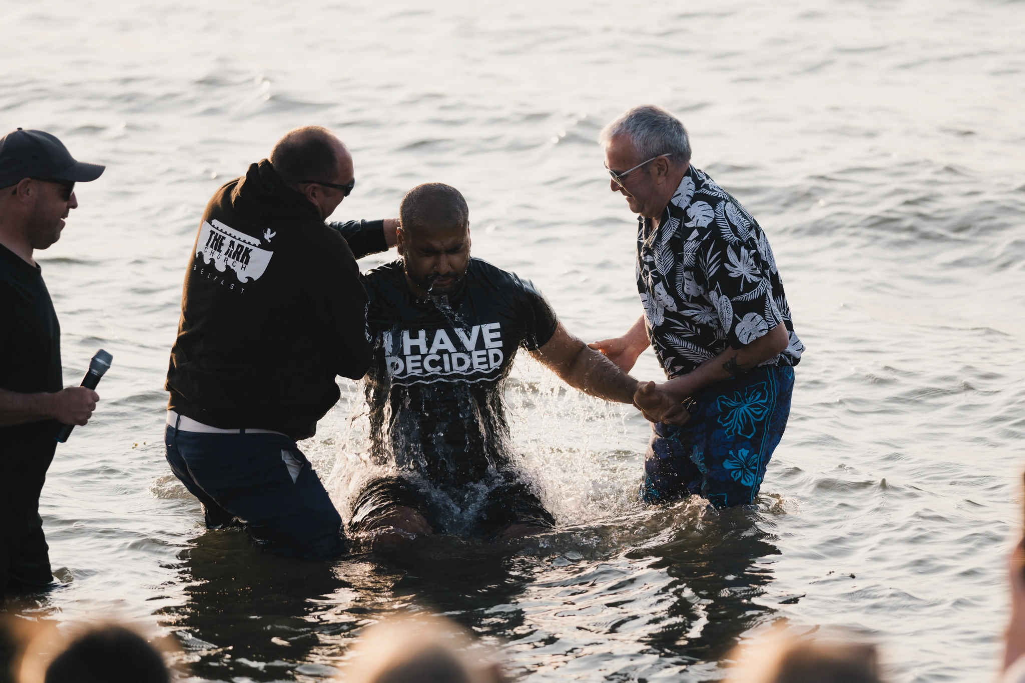a man is baptized in the water by a group of men and women