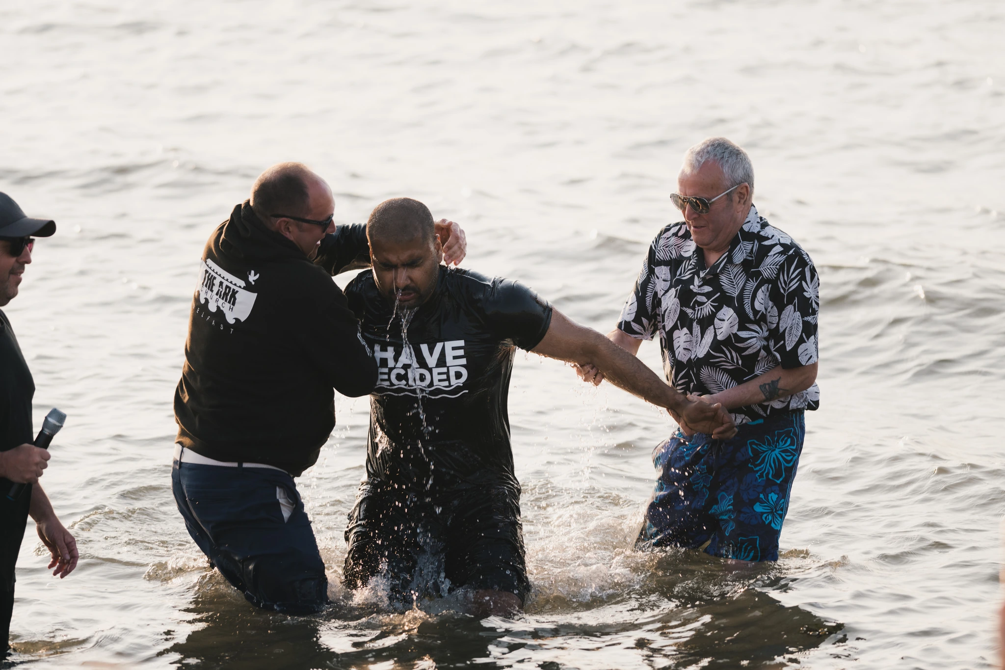 a man is being baptized in the water by a priest