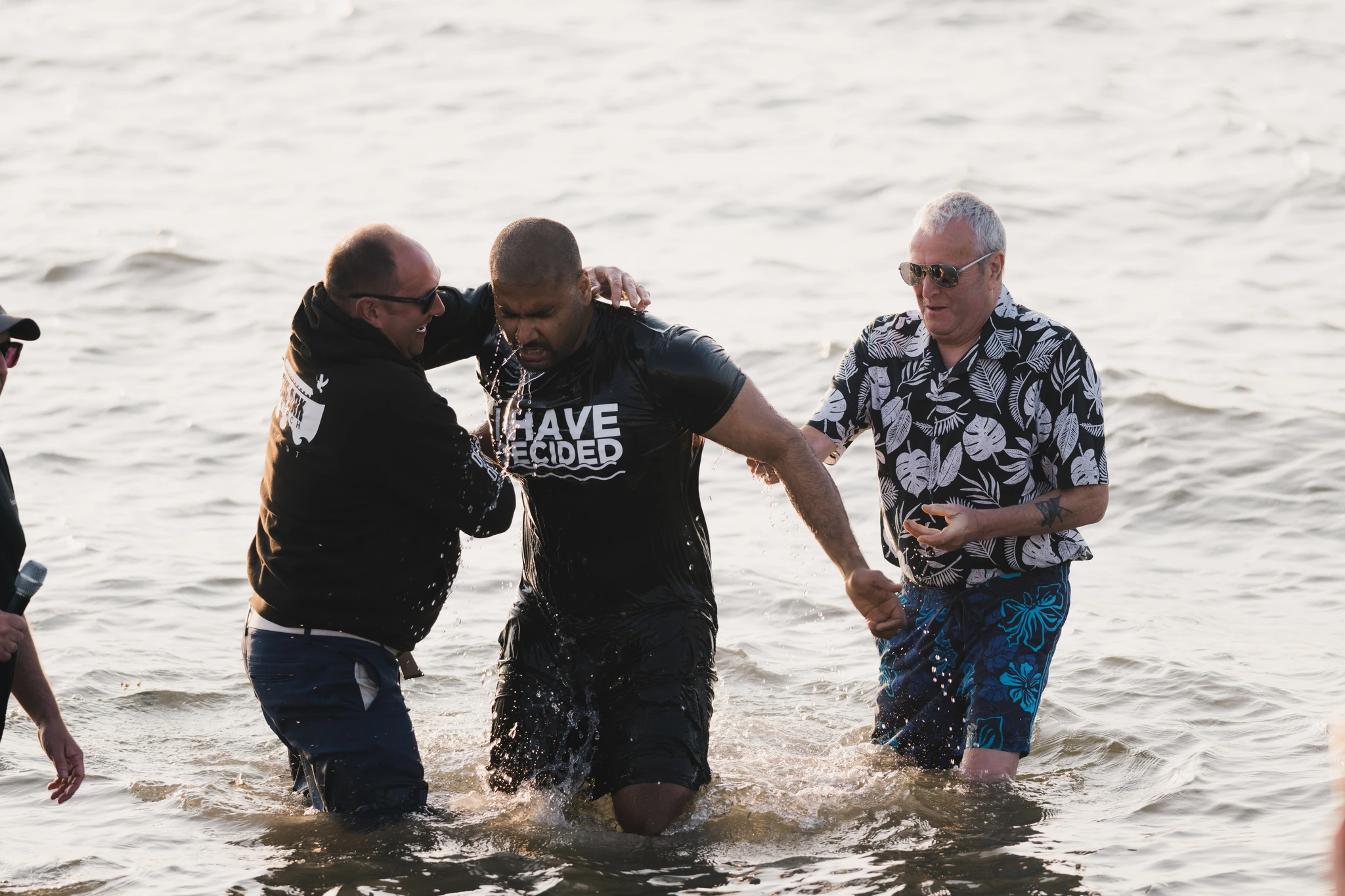 a group of men and women stand in the water as they are baptized