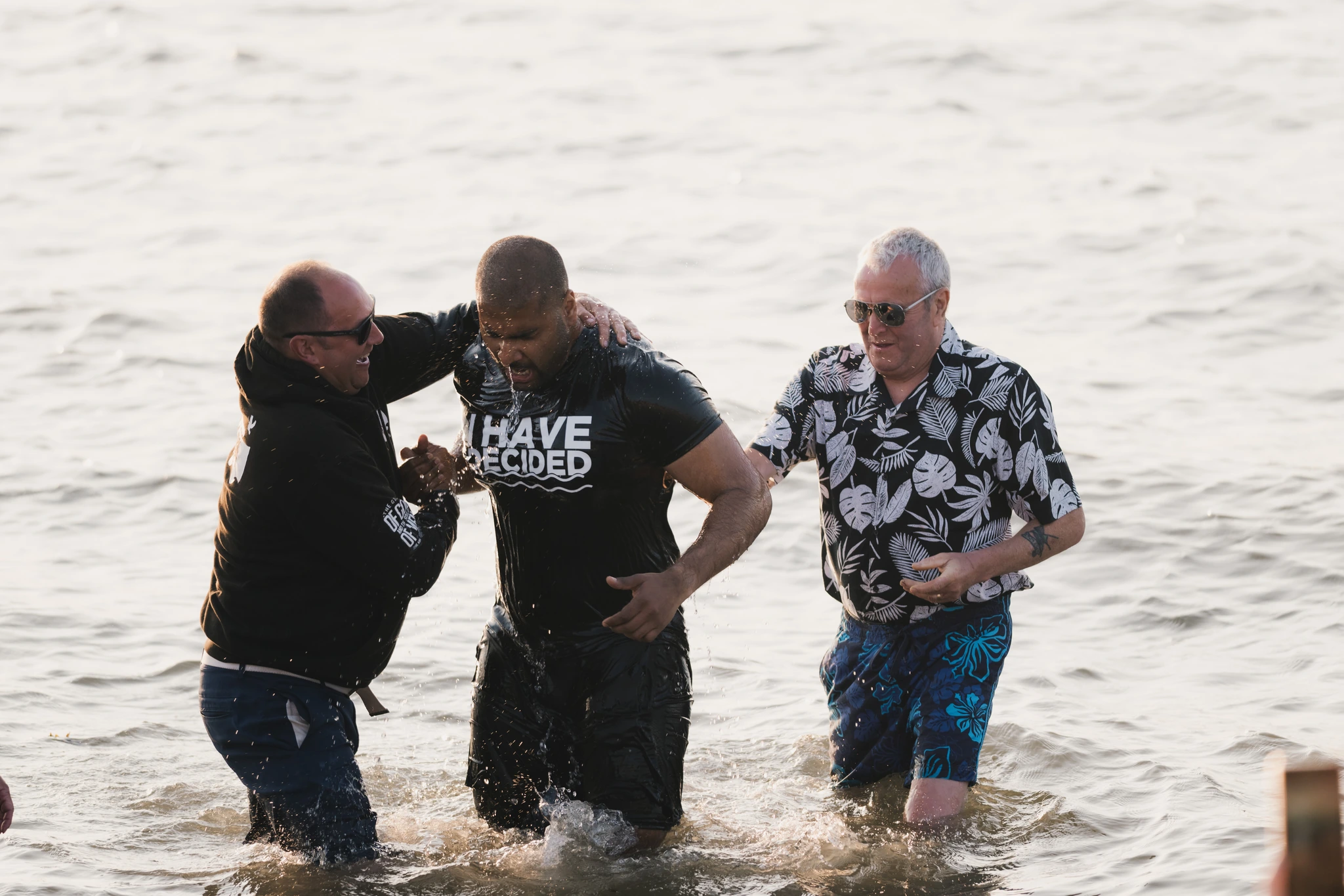 a group of men and women stand in the water at a baptism ceremony at the christian church in london, england on saturday