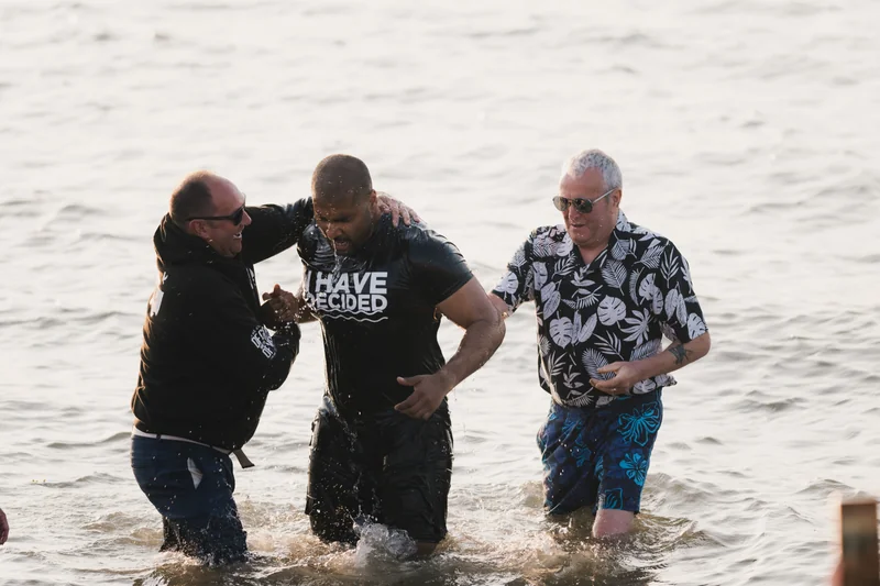 a group of men and women stand in the water at a baptism ceremony at the christian church in london, england on saturday