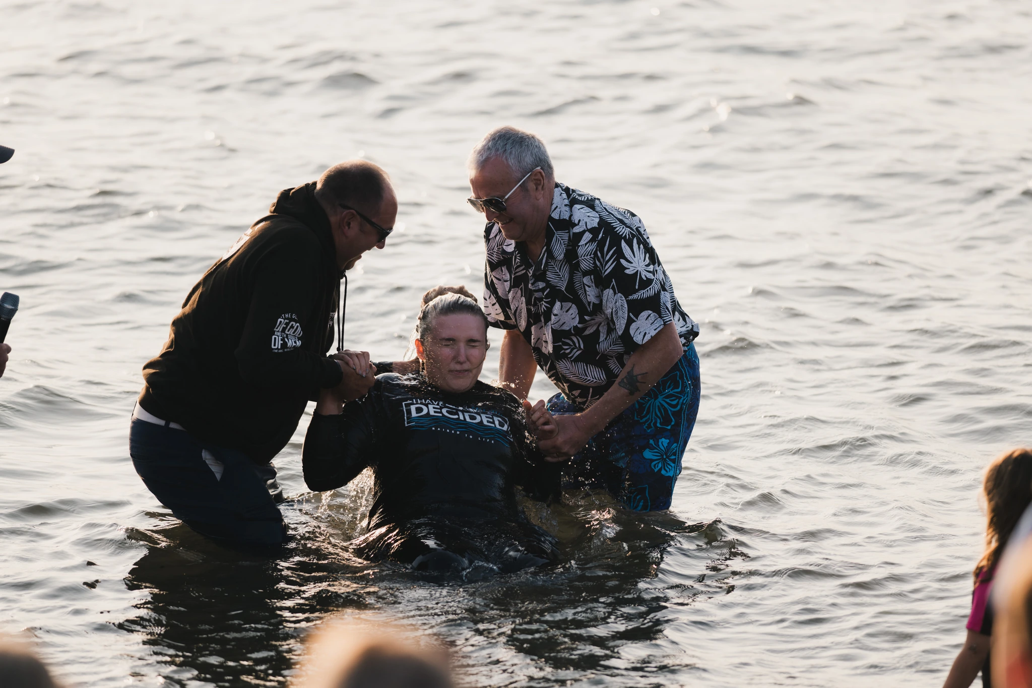 a man in the water with a woman standing behind him