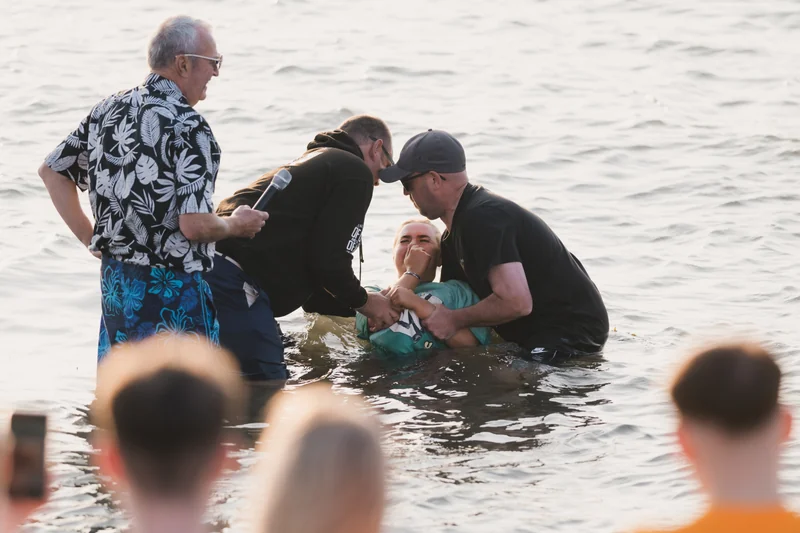 a man in the water with a woman standing next to him