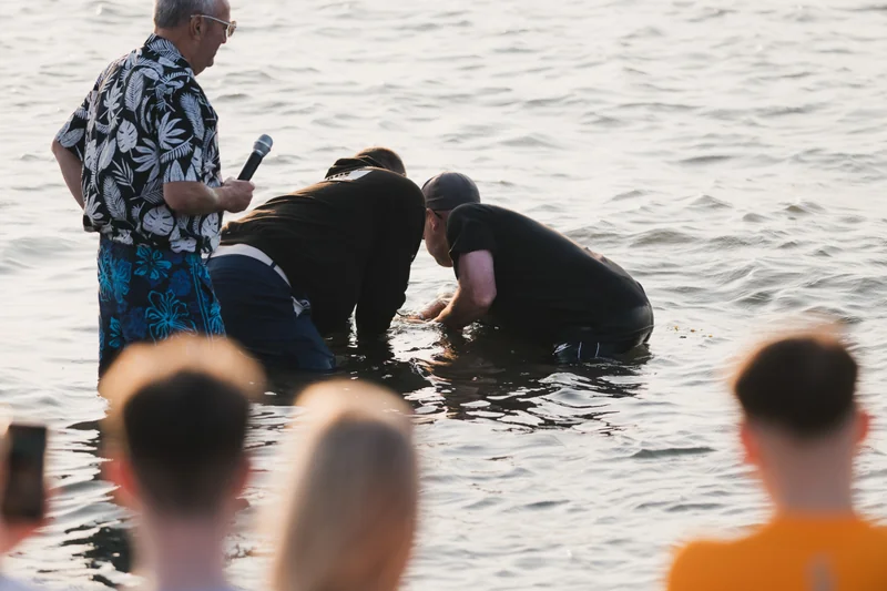 a man is standing in the water while a woman is standing behind him