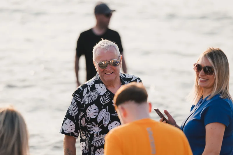 a man and woman in a group of people on a beach in hawaii