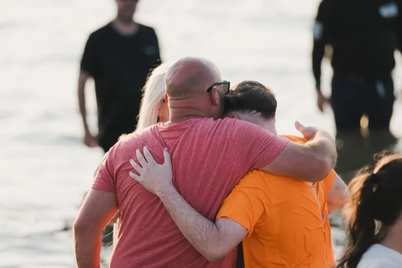 a man and woman hugging each other in the water