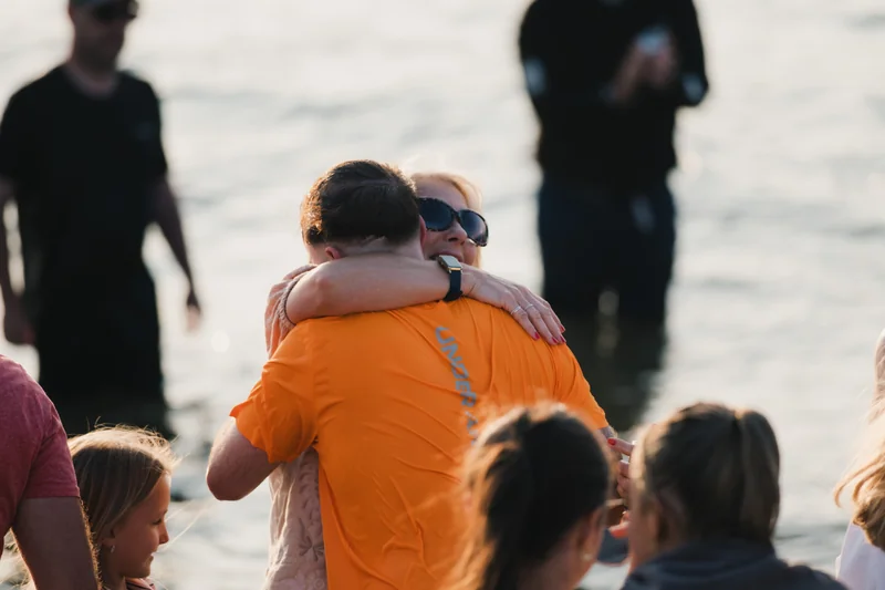 a group of people hugging each other in the water