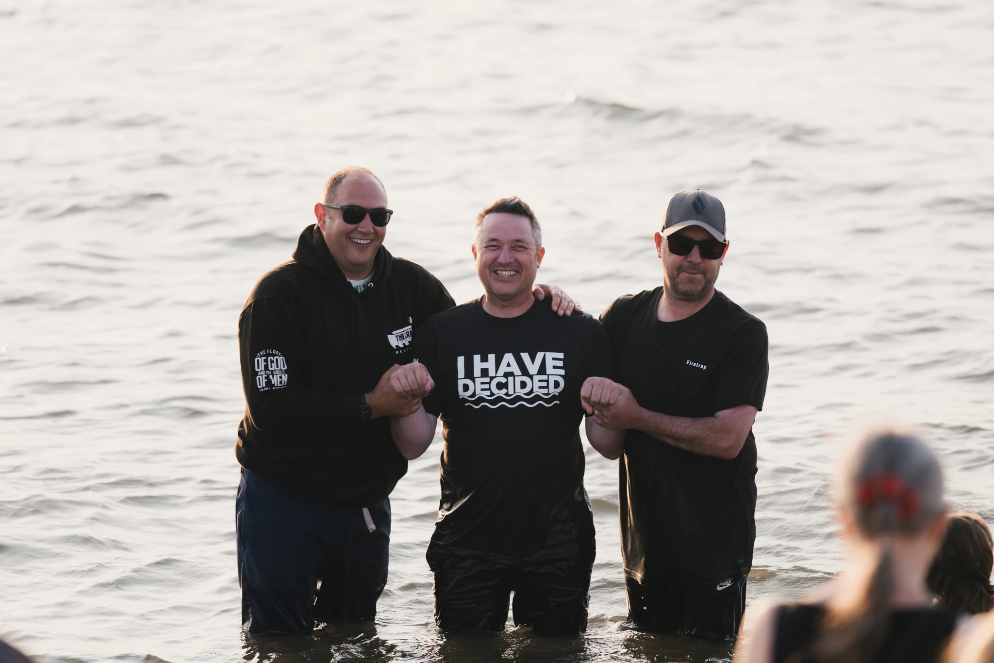 a group of men and women standing in the water with a sign that says have a good day
