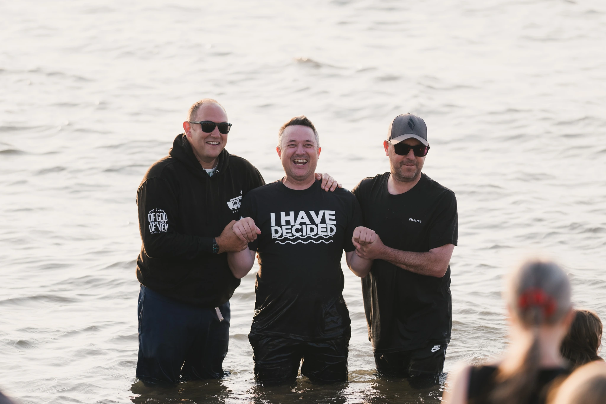 a group of men standing in the water with a sign that says have a good day