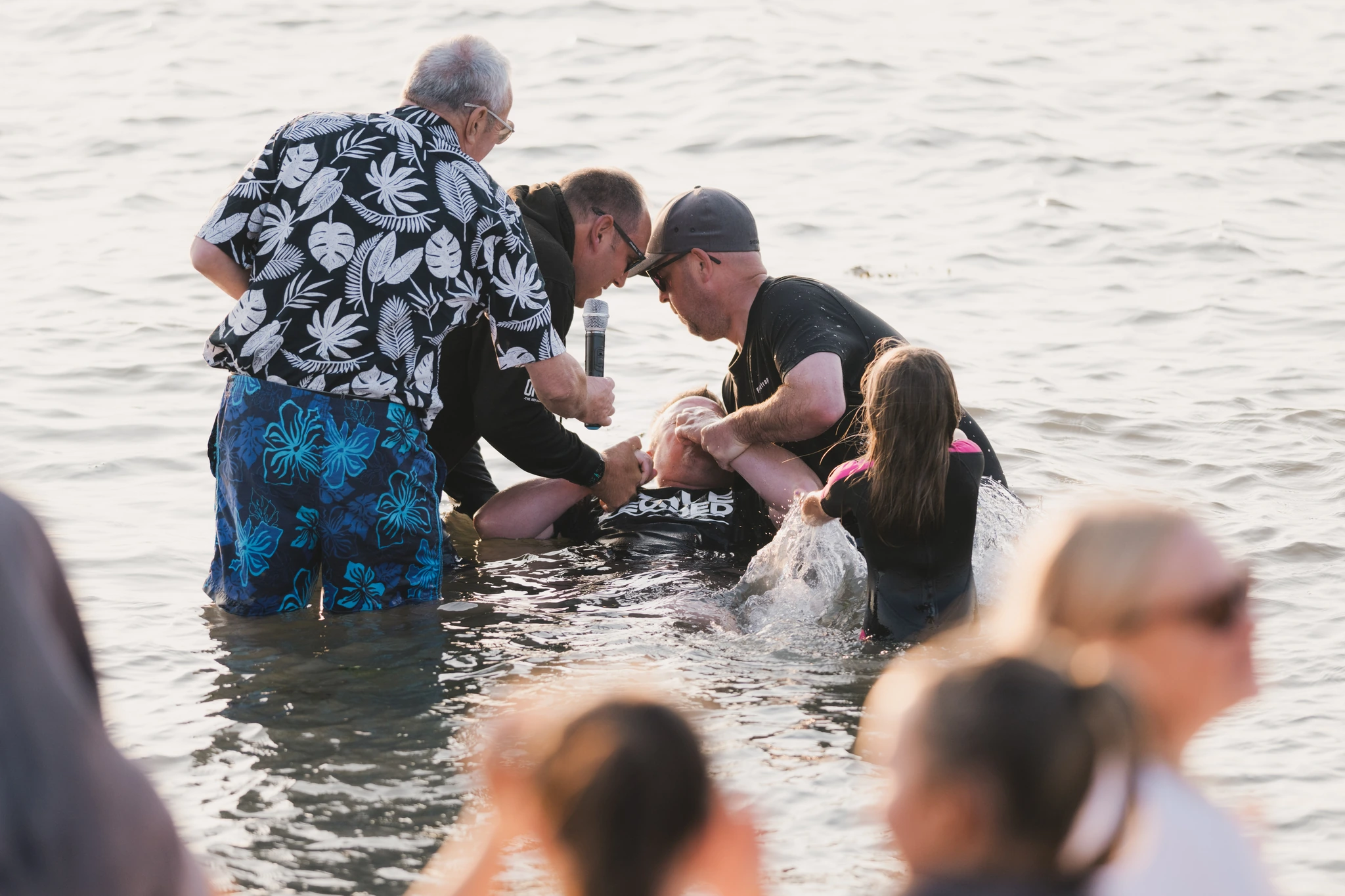 a group of people standing in the water with a person in the middle