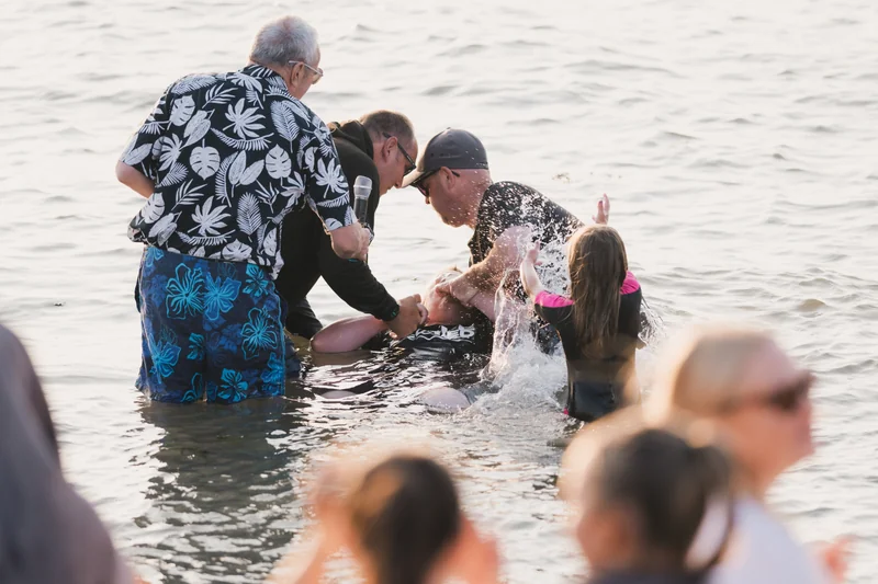 a group of people standing in the water with a person in the middle