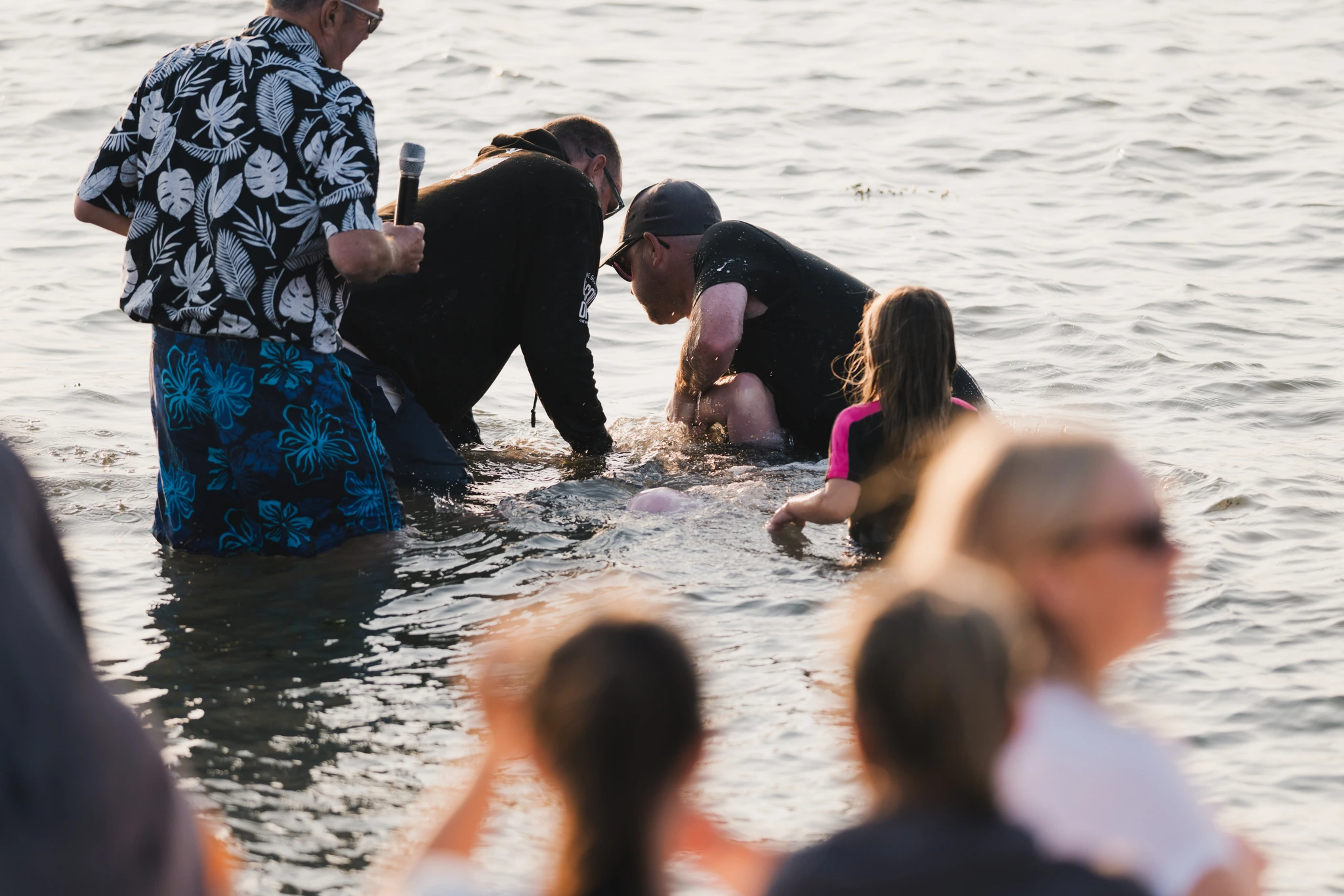 a group of people standing in the water with a person in front of them
