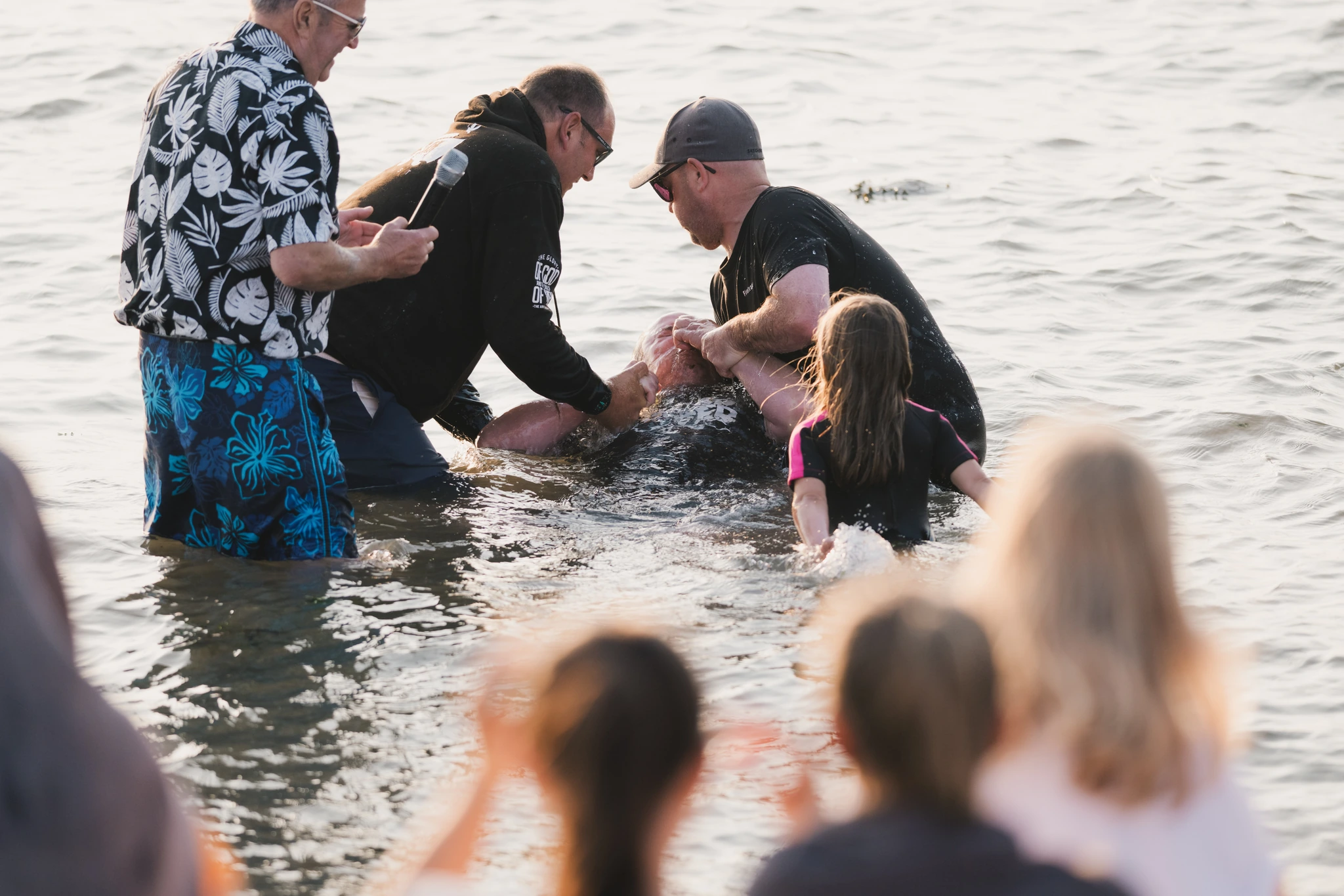 a group of people standing in the water with a person in the middle