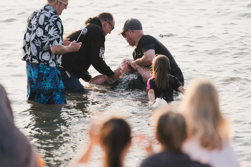 a group of people standing in the water with a person in the middle