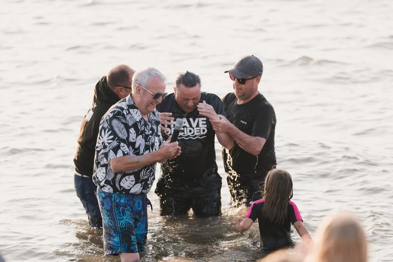 a group of people standing in the water