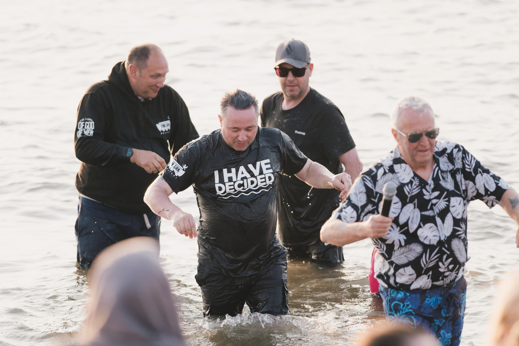a group of people standing in the water with a sign saying 'have faith'