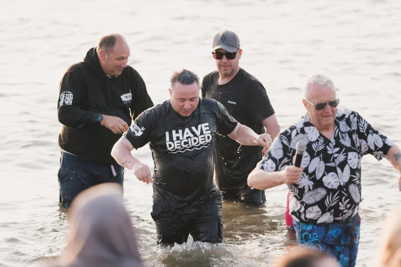 a group of people standing in the water with a sign saying 'have faith'