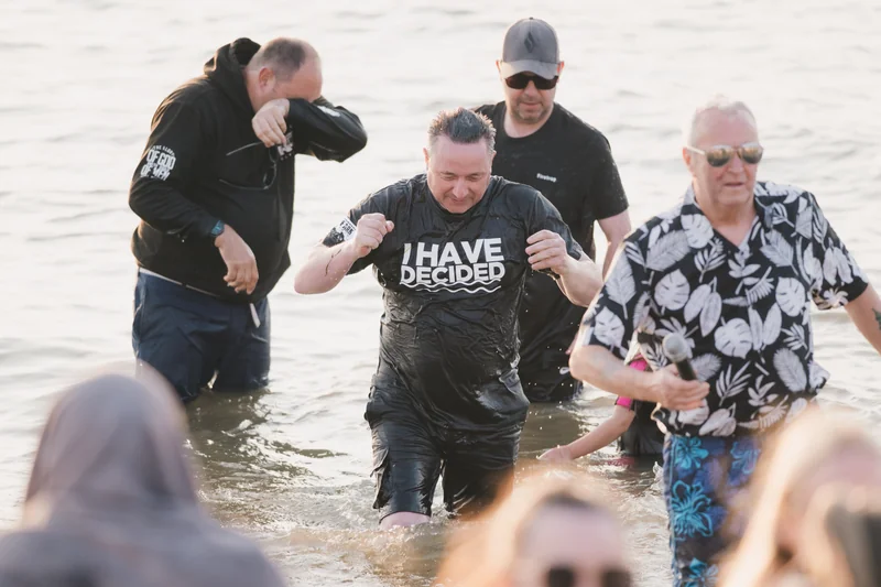 a group of people standing in the water with a sign saying have a good day