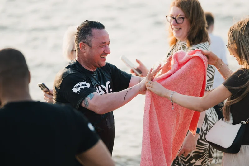 a man is holding a towel while a woman is standing next to him
