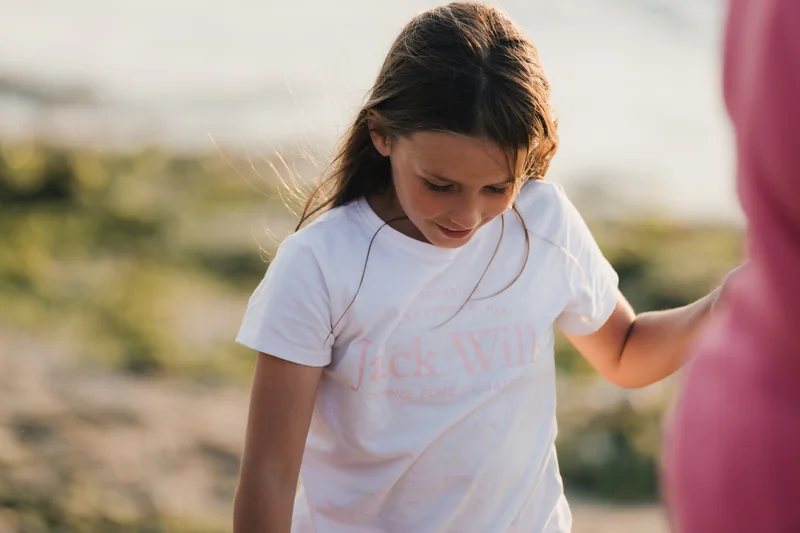 a girl wearing a white t-shirt and a pair of blue jeans