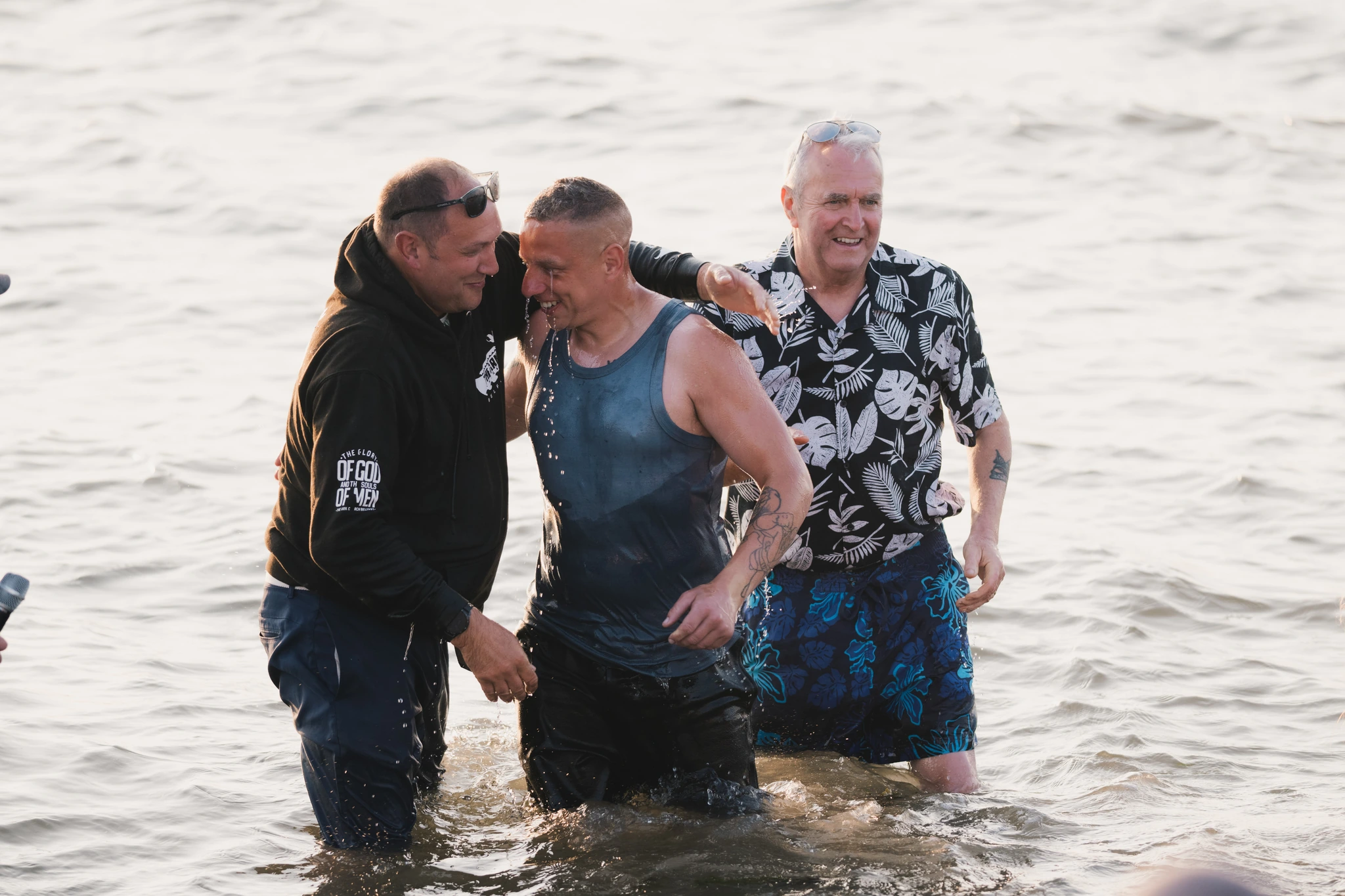 a man wading a young boy in the water