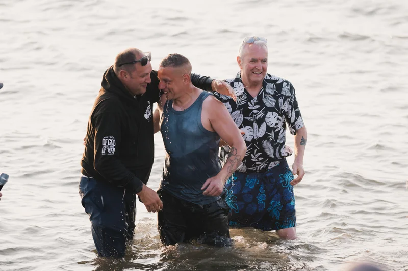 a man wading a young boy in the water