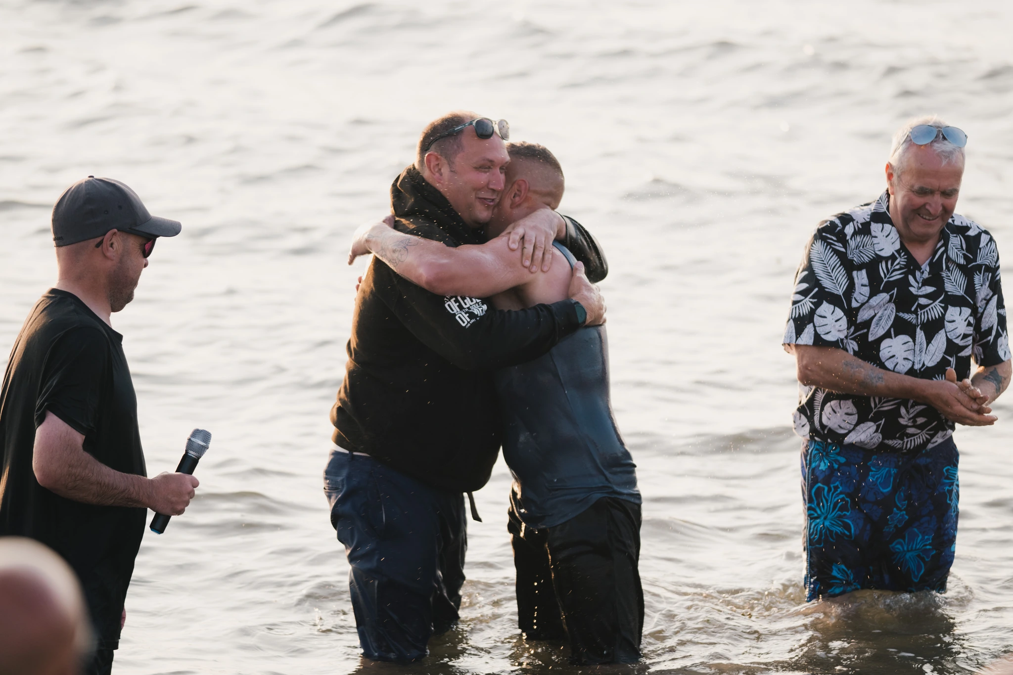 a man is embraced by another man in the water as he swims in the ocean