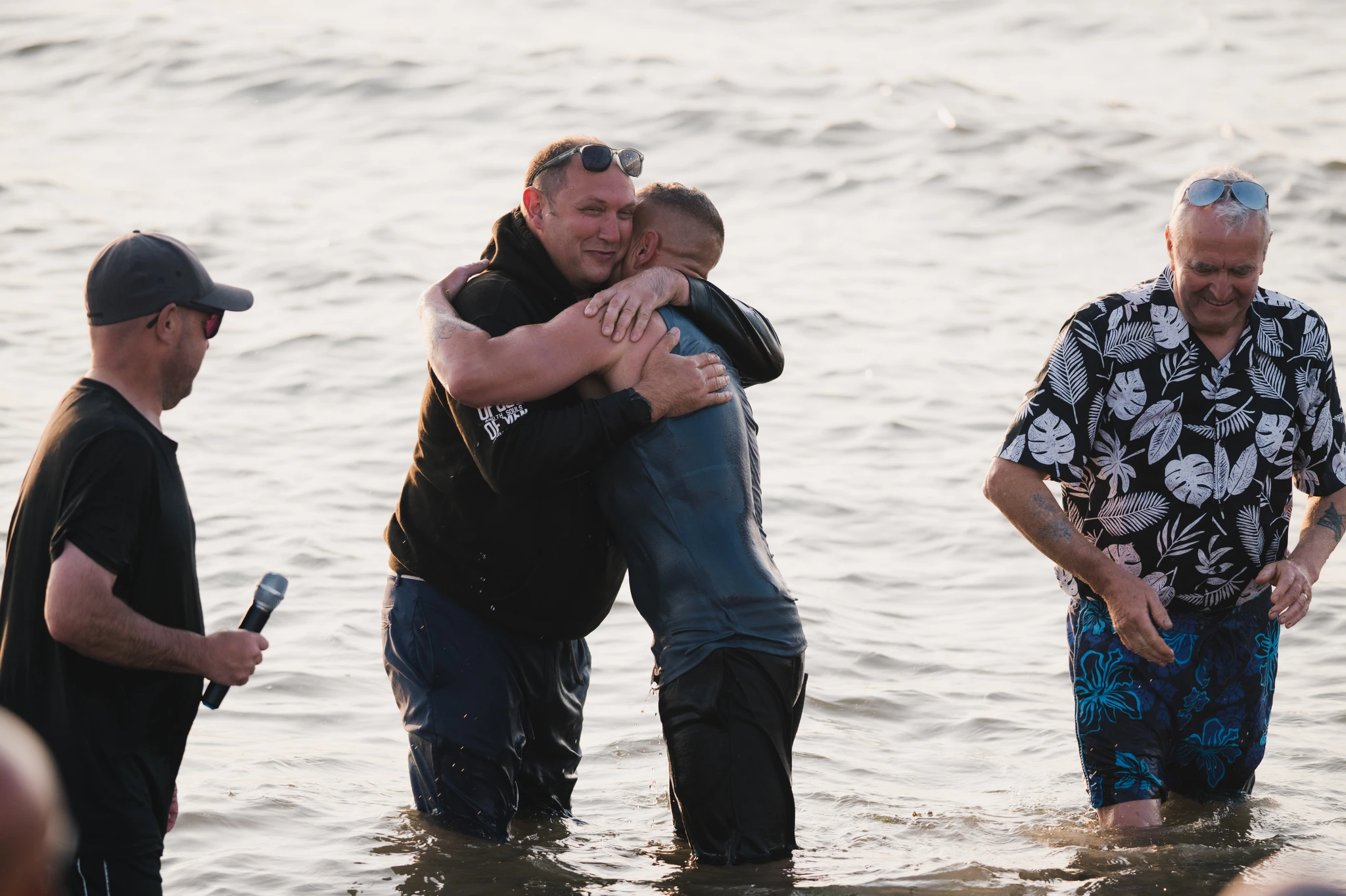 a man is embraced by another man in the water as he swims in the ocean
