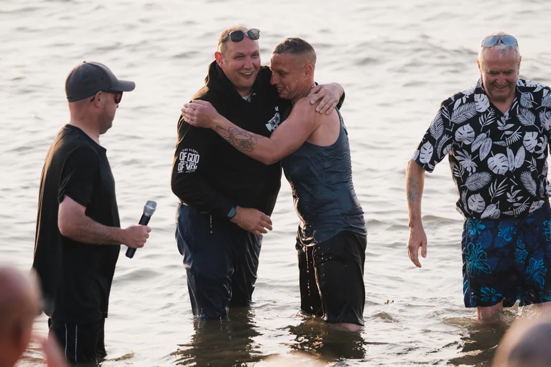 a man in the water with a group of men standing in front of him