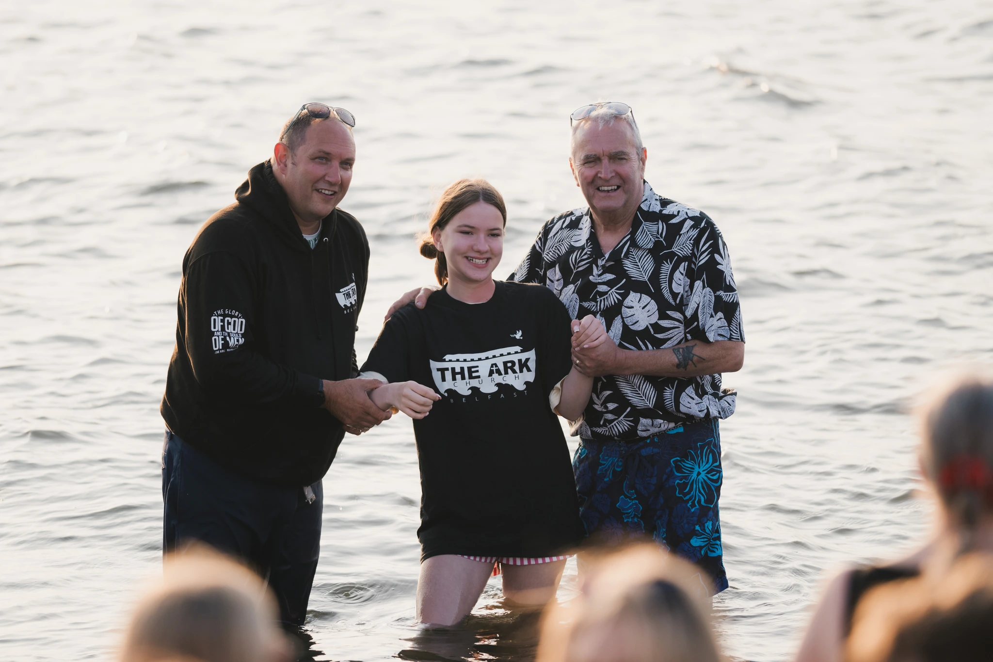a man and woman are standing in the water with a woman in front of them